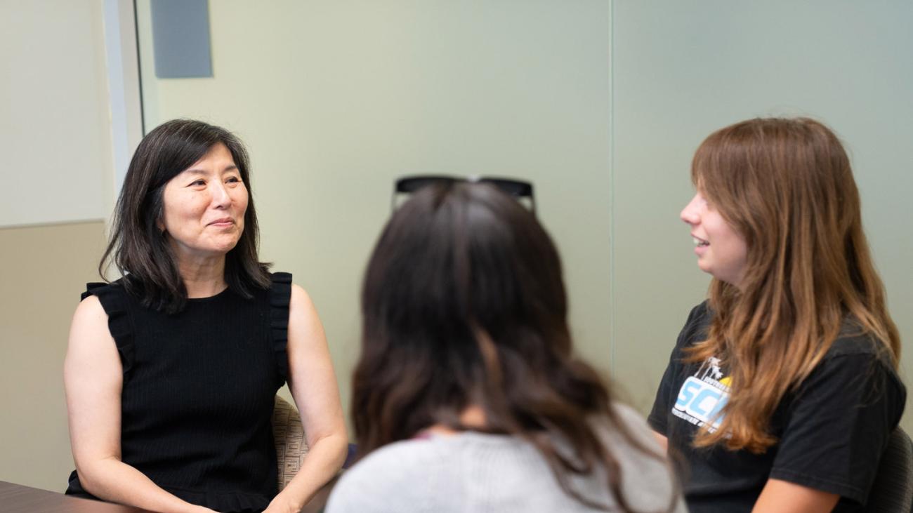 Professor Sharon Goto in discussion with two students
