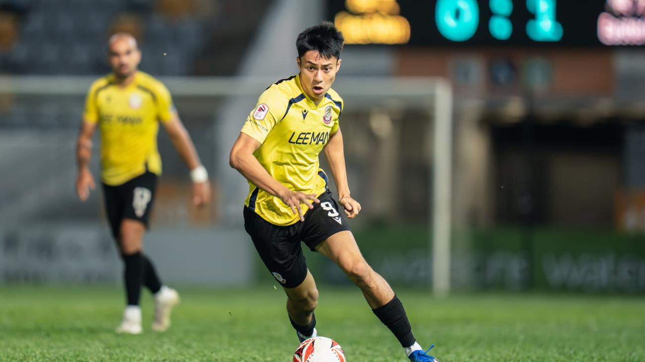 Kyle Lau dribbles a soccer ball