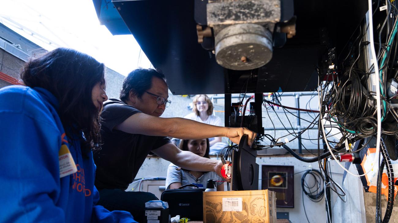 Students and faculty work with a telescope