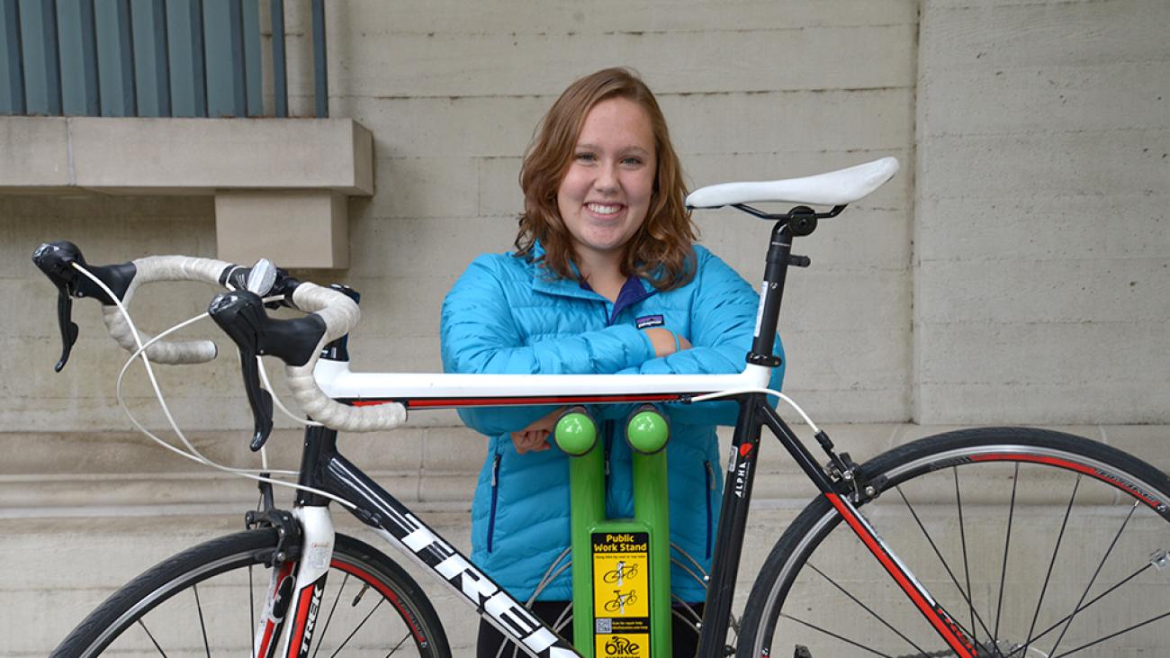 A student with her bike at the bike maintenance station available to students