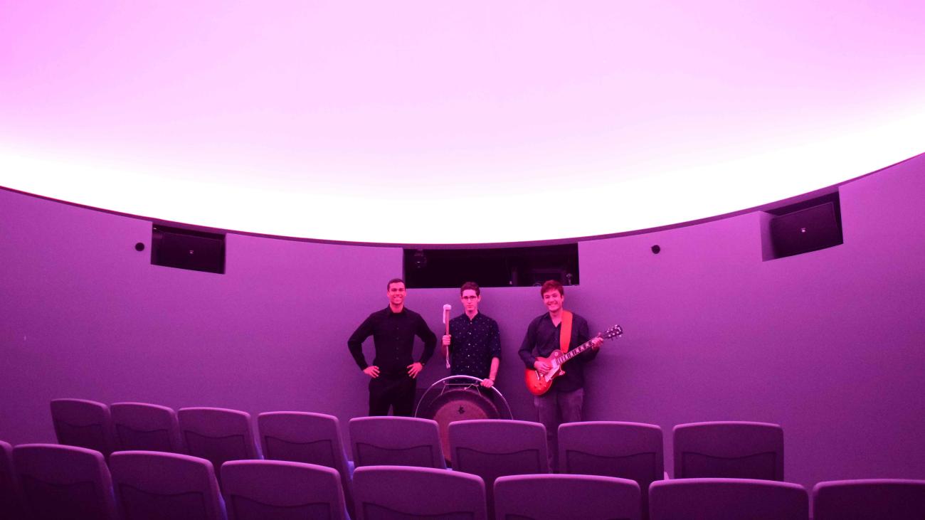students inside planetarium holding musical instruments
