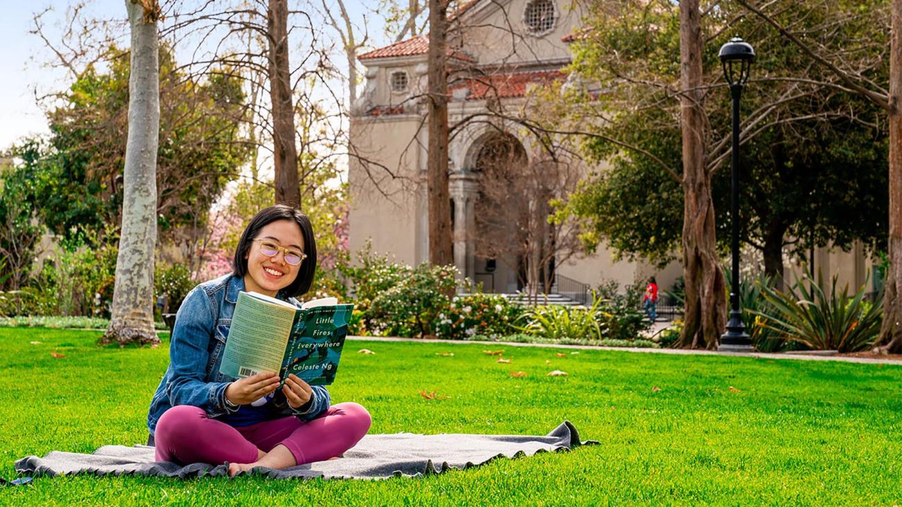 Student reads a book on Marston Quad