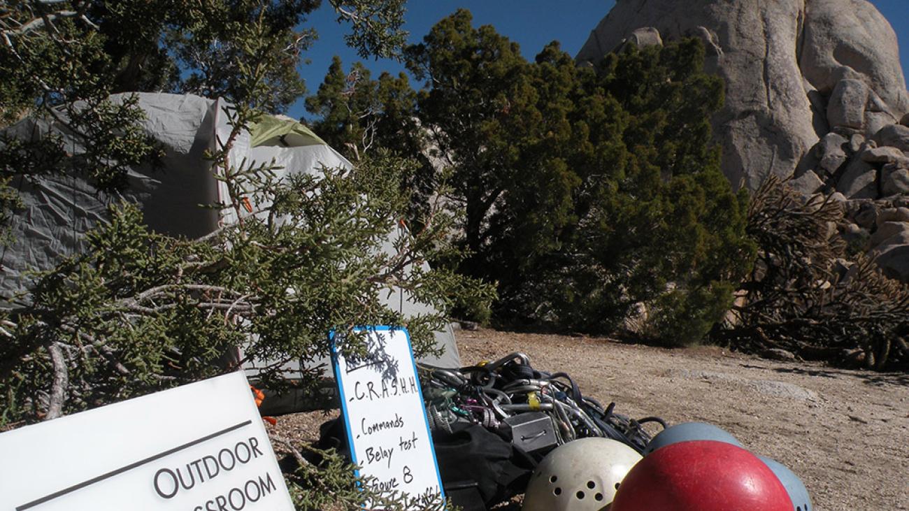 Helmets sit on a path outside a tent