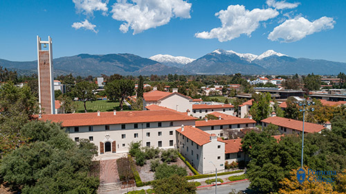 aerial shot of pomona college with mountains and clouds in the background