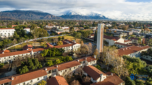 aerial of pomona college with the claremont colleges and snow-capped mountains in the background