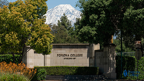 pomona college welcome sign in front of snow-capped mountains